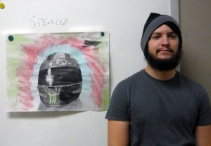 Student standing beside drawing of helmet.