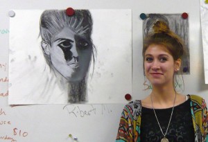 Student posing with her portrait.